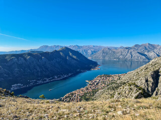 Naklejka premium Panoramic view of the bay of Kotor in summer, Adriatic Mediterranean Sea, Montenegro, Balkan Peninsula, Europe. Fjord winding along the coastal towns. Lovcen and Orjen mountain range, Dinaric Alps