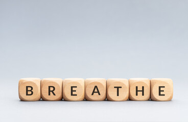 Breathe word on wooden blocks on gray background. Copy space
