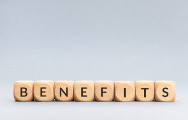 Benefits word on wooden blocks on gray background. Copy space