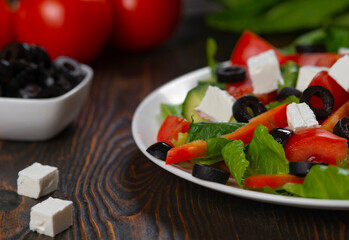 Greek salad. Vegetable salad with tomato, cucumber, salad leaves, feta cheese and olive oil.
