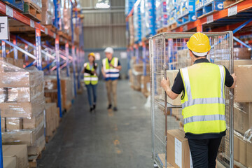 2 Staff in large depot storage warehouse manager and trainee walking check goods on shelf and radio