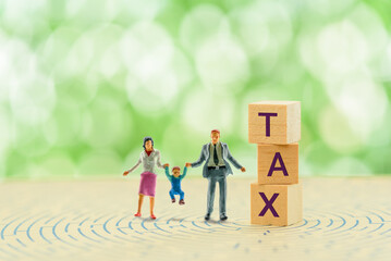 High income child benefit tax charge, financial concept : Couple holds a toddler near wood cubes...