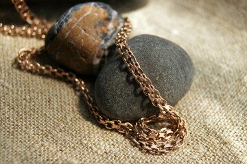 Gold chain and stones on natural linen fabric.