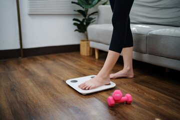 Woman leg stepping on scales at home. Measurement instrument in kilogram for diet Lose weight...