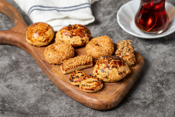 Salty cookies on a dark background. Types of sesame and seed cookies on a wooden serving plate. close up