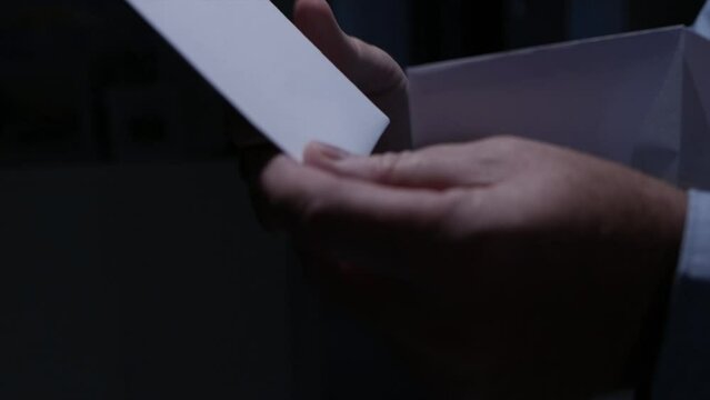 Blurred Shooting with a Person Opening an Envelope and Reading a Letter. Businessman Receiving a Document by Postage.