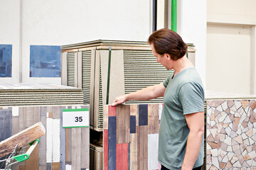 Man chooses and buys decorative wall panel in store