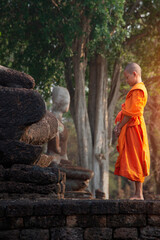 Asian Novice monks vipassana meditation at front of Buddha statue