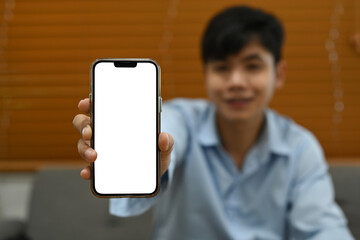 Man hand showing mock up smart phone with white empty screen for your advertise design