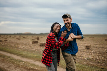 Couple having fun and enjoying relaxation in a wheat field. Ranchers sharing love. The concept of youth, love, and lifestyle.