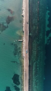 Bird's-eye view of the road passing through the middle of the sea in izmir urla with drone
