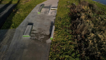 Skateboard park with concrete cement surface with concrete skateboard obstacles is designed for roller sports. Cycling is not allowed except for freestyle bikes.  winter morning sunrise, above, high