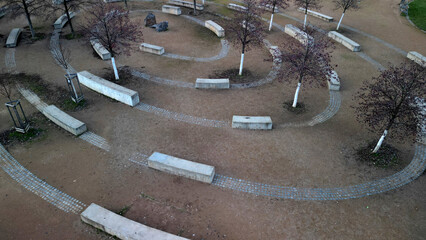 massive concrete blocks of bench in the park are connected by granite blocks in the shape of a...