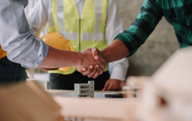 Engineer and contractor join hands after signing contract,They are having a modern building project together. successful cooperation concept..