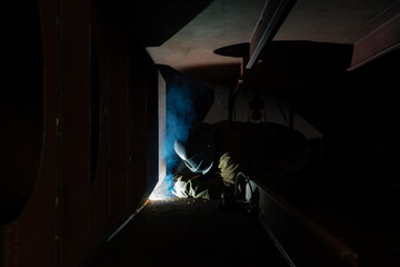 Obraz na płótnie Canvas Welder welding in a shipyard a steelblock