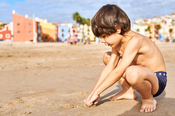 elementary age kid playing on the beach sand