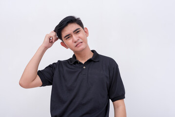 An exasperated young asian man scratching his head. Regretting a mistake he made. Isolated on a...