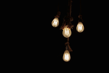 tungsten light bulb lit on black background