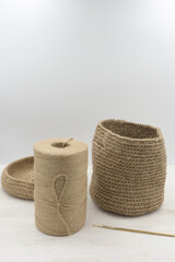 Fototapeta na wymiar Jute knitted bag and jute babina yarn on a white wooden table