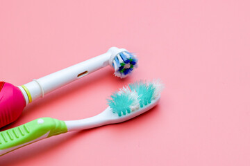 Closeup Old electric toothbrush and normal toothbrush with frayed bristles in close-up view. Expired toothbrush with worn damage brush isolated on pink background. Oral care concept. - obrazy, fototapety, plakaty