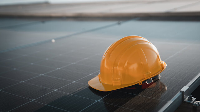 Yellow engineer hard safety helmet hat on solar cell panel., Solar panel concept.