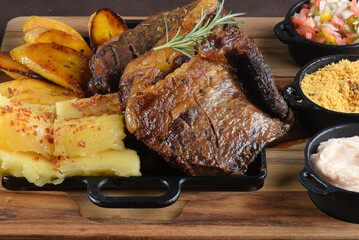 Grilled Chuck Eye Roll Steak roasted on a chopping board. bbq barbecue with rice beans salad. top view