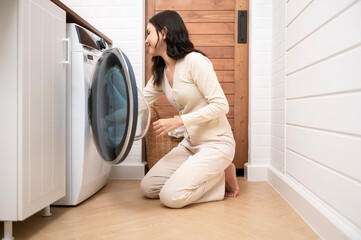 Happy Asian young woman is doing laundry in home , healthy lifestyle concept