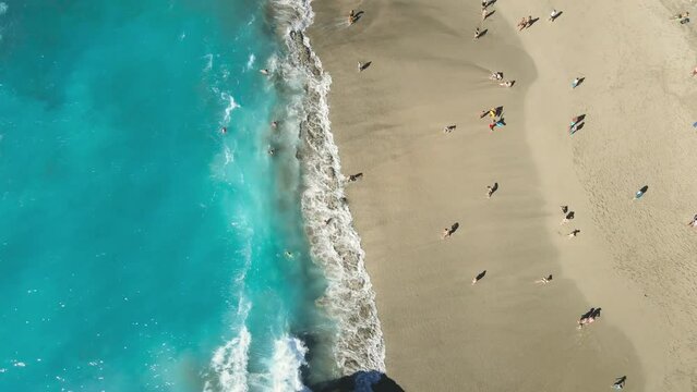 Aerial view of tourists enjoying the beach and waves on Tenerife island. Playa del Duque with atlantic ocean.