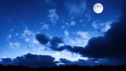 Fototapeta na wymiar Dramatic nighttime clouds and sky with a beautiful blue moon.