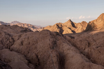 Beautiful stone mountains in the desert. Yellow sand on the mountains. Evening nature. Sunny summer day.