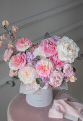 A luxurious bouquet of flowers in a hat box. Composition with pink and white flowers and eucalyptus in a box. Modern Floristry.