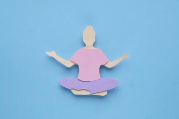 Woman`s health. Paper female figure on light blue background, top view