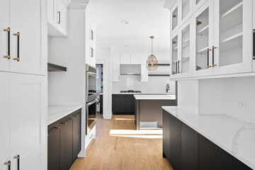 Modern Black and White White Kitchen with Stainless Steel Luxury Appliances. Contemporary dual tone cabinets with white marble slab backsplash. Empty Kitchen for virtual staging.