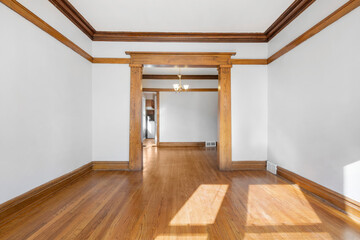 Vintage Living Room with Hardwood Floors. White walls with vintage wood trim. Empty room for...