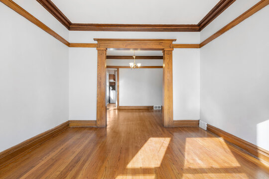 Vintage Living Room with Hardwood Floors. White walls with vintage wood trim. Empty room for virtual staging. 