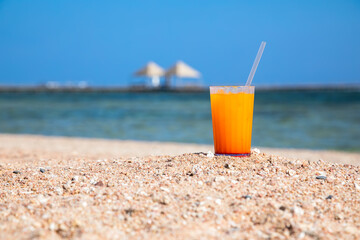 Beautiful cocktails on the sand near the sea shore. Glasses with summer cocktails. Yellow sand on the beach. Sunny summer day.