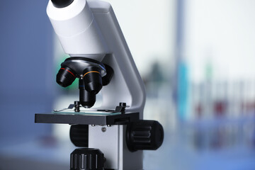 Modern medical microscope with glass slide in laboratory, closeup. Space for text