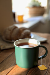 Tea bag in cup on wooden table indoors