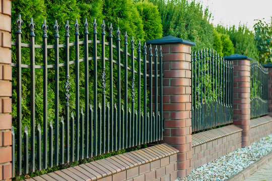 Beautiful brick fence with iron railing outdoors