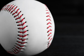 Baseball ball on black background, closeup with space for text. Sports game