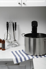 Pot with sous vide cooker in kitchen. Thermal immersion circulator