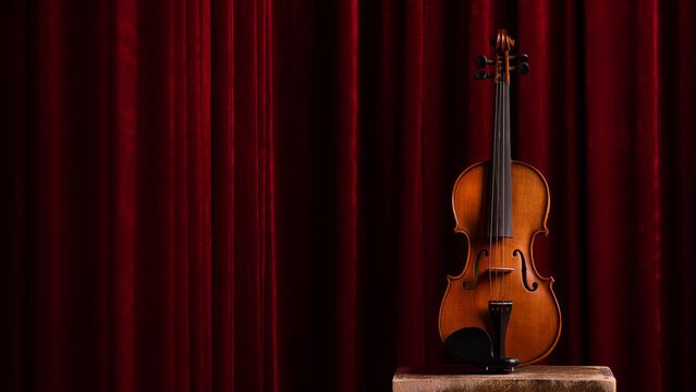 Retro vintage violin on red theater curtains background