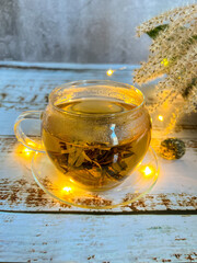 Opening of a tea flower in hot water.Green tea.Decorated with a garland
