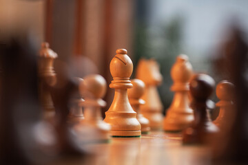 Wooden white chess pieces on a board