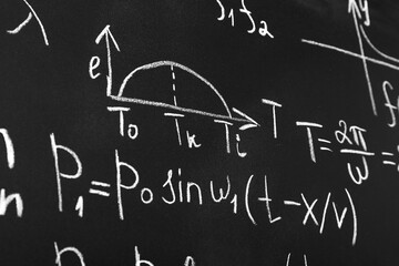 Many different math formulas written on chalkboard, closeup