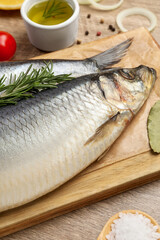 Delicious salted herrings and ingredients on wooden table, closeup