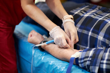 a nurse takes a blood sample.Close up Hand of a nurse or doctor in gloves taking a blood sample from a patient in a hospital. Close up Of Doctor Injecting Patient With Syringe To Collect Blood Sample