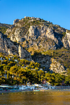 Panoramic View Of Alpes Mountains And Slopes With Cap Estel Cape Over Eze Sur Mer Resort Town And Beach On French Riviera Coast Of Mediterranean Sea In France