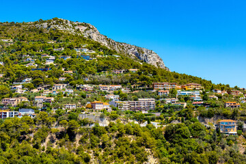 Fototapeta na wymiar Panoramic view of Eze town valley among Alpes hills and residential area with summer houses and villas on French Riviera Coast of Mediterranean Sea in France