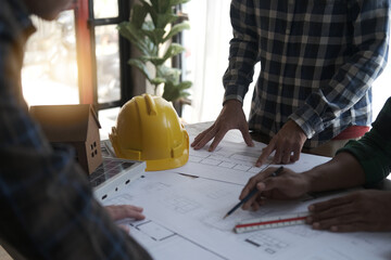 Team architect and engineer meeting and consult with blueprint and computer in architecture office.